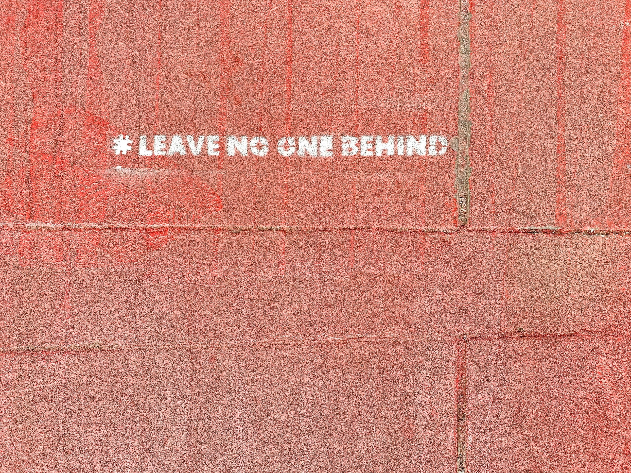 Frase “Leave No One Behind” sobre fondo neutro, como símbolo de que ningún migrante debe quedar fuera del acceso a información importante sobre temas migratorios.