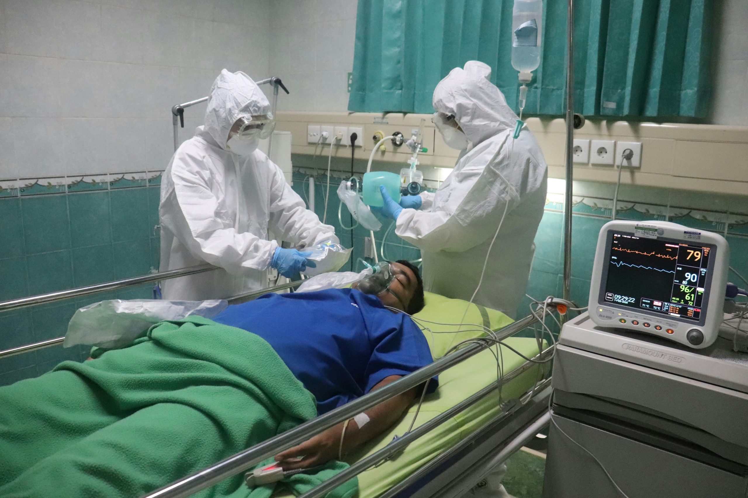 Paciente migrante en camilla siendo atendido por doctores bajo el programa Medi-Cal